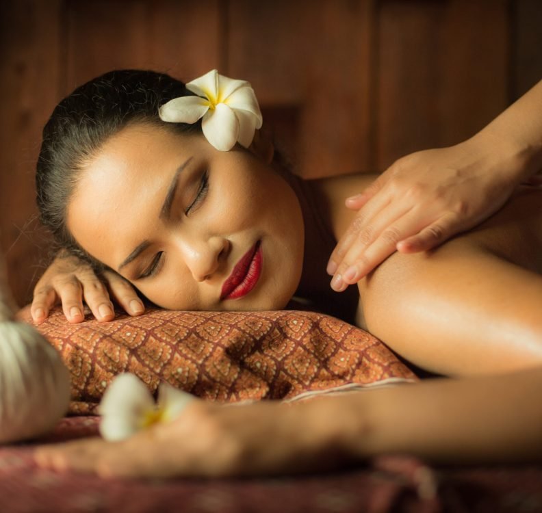Masseur doing massage on Asian woman body in the spa salon